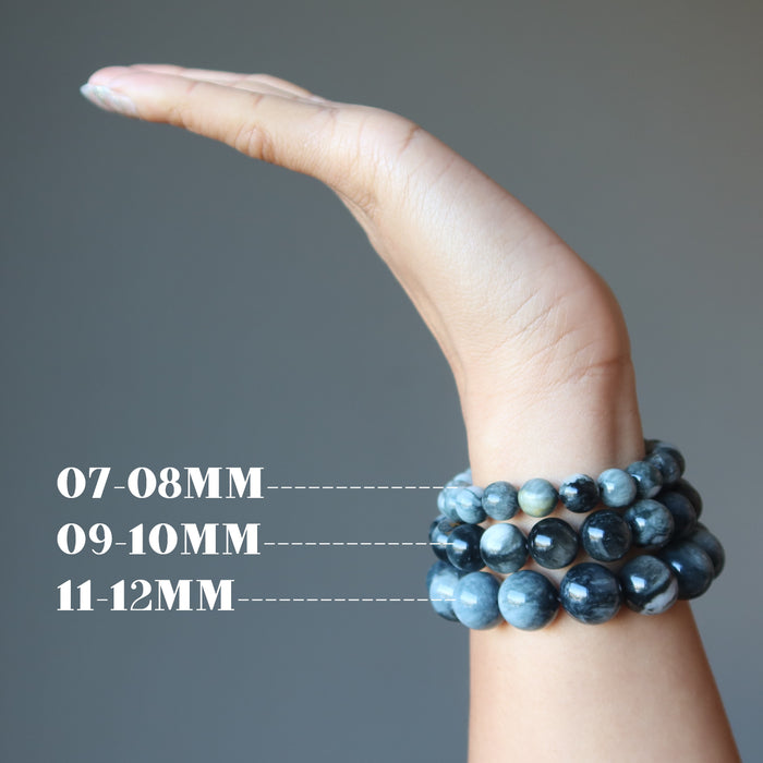 hand wearing three sizes of cats eye quartz bracelets