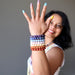 sheila of satin crystals wearing set of 7 chakra bracelets with amethyst, sodalite, angelite, rose quartz, calcite, aventurine and red jasper holding a tibetan singing bowl