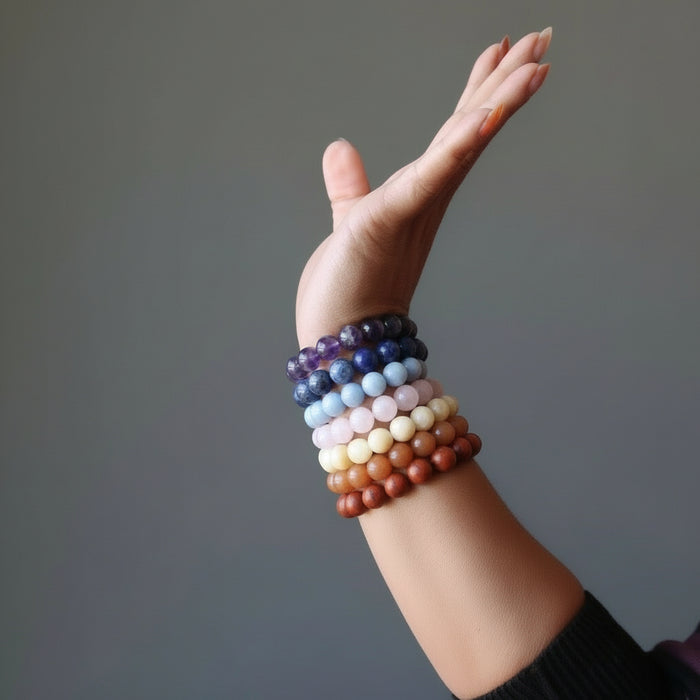 sheila of satin crystals wearing set of 7 chakra bracelets with amethyst, sodalite, angelite, rose quartz, calcite, aventurine and red jasper