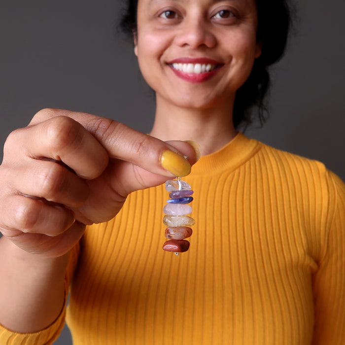 sheila satin holding a stacked gemstone chakra pendant 