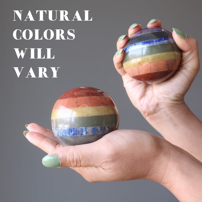 pair of hands holding chakra spheres in each showing natural colors will vary