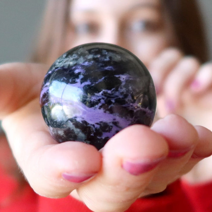 female model holding a Purple Charoite Sphere