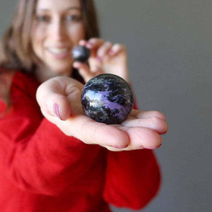 palm holding Purple Charoite Sphere