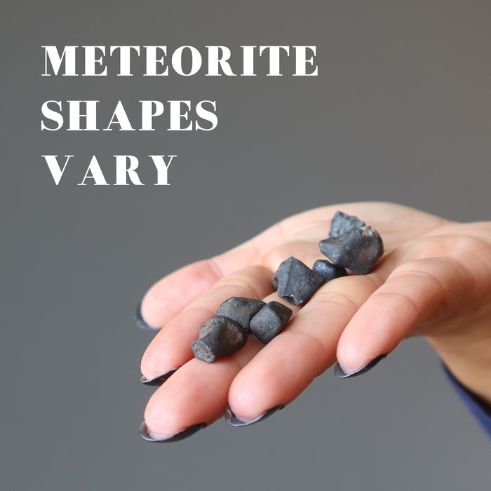 hand holding rocky brown chelyabinsk meteorites to show natural shapes vary