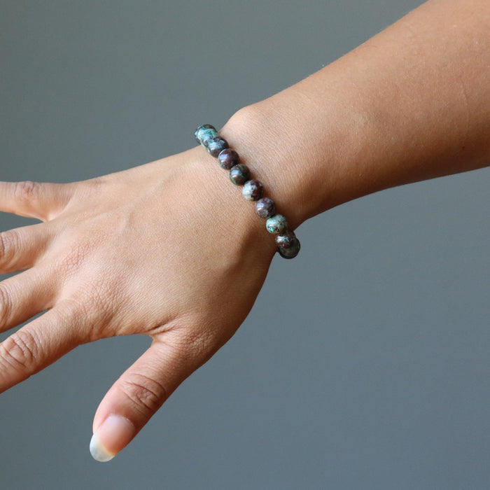 female hand model wearing chrysocolla cuprite bracelets
