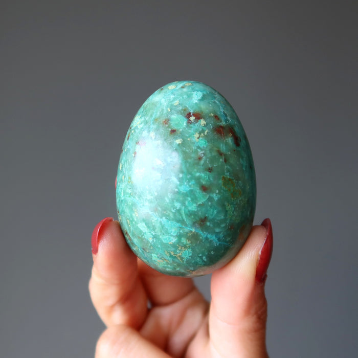 hand holding chrysocolla egg