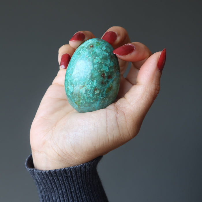 hand holding chrysocolla egg