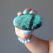 hand holding blue-green and black chrysocolla oval cabochon