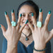 woman wearing two chrysocolla rings