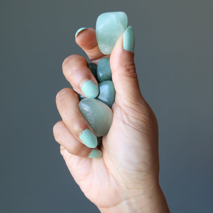 hand holding green aventurine tumbled stone set 
