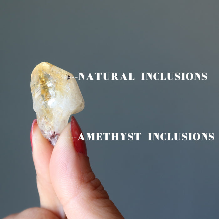 hand holding citrine point showing natural inclusions