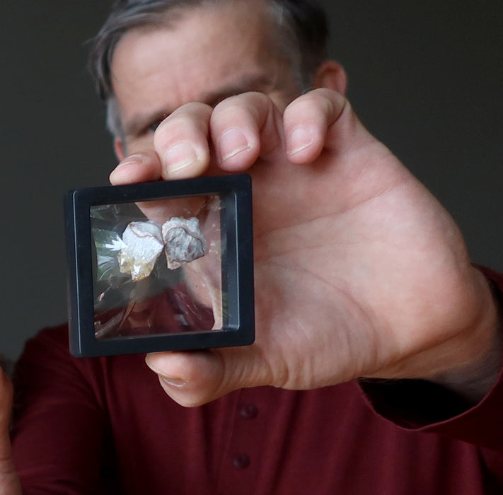 man holding yellow citrine cluster pairs in suspension case