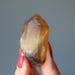 hand holding raw yellow citrine point