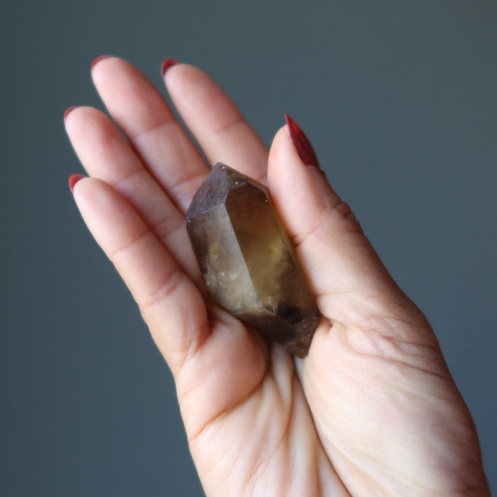hand holding raw yellow citrine point