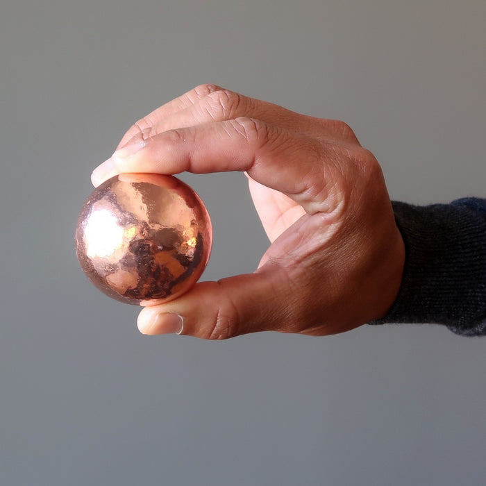 hand holding a copper alchemist sphere