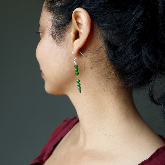 sheila of satin crystals displaying left side of green Chrome Diopside dangling on stars sterling silver earrings