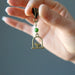 hand holding Swinging Bird green Diopside Pendant