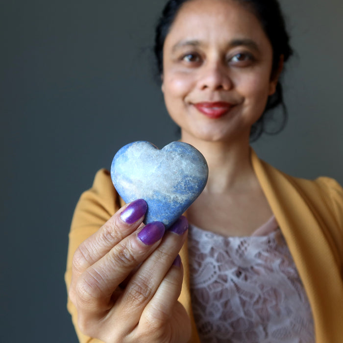 woman holding a dumortierite crystal heart