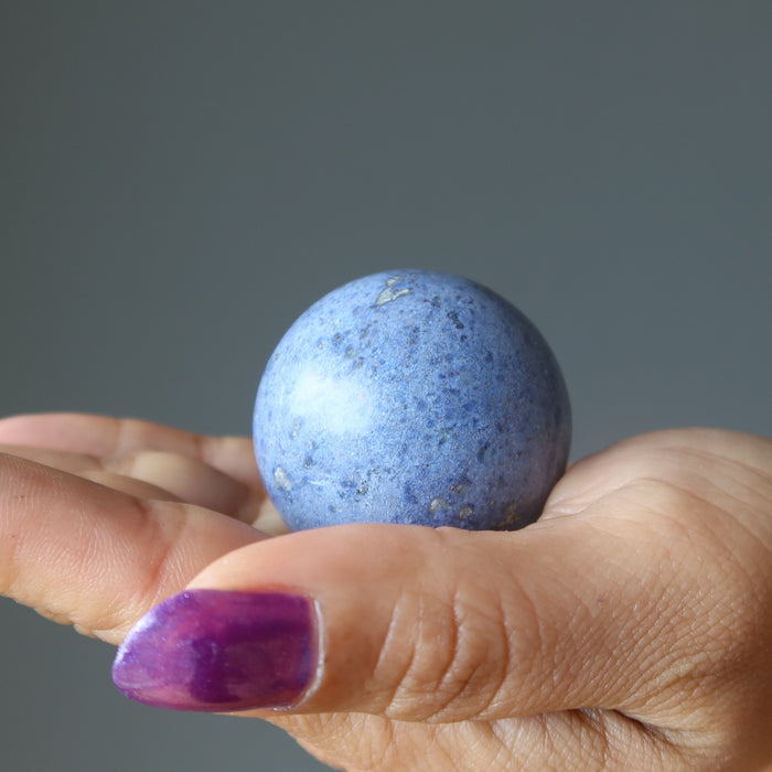 blue Dumortierite Sphere on the palm