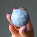 hand holding blue Dumortierite Sphere