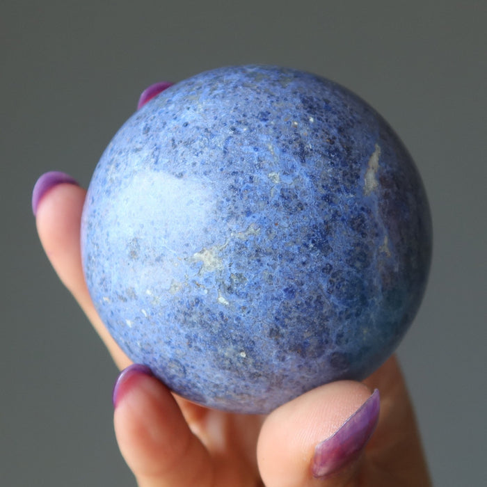 hand holding blue Dumortierite Sphere