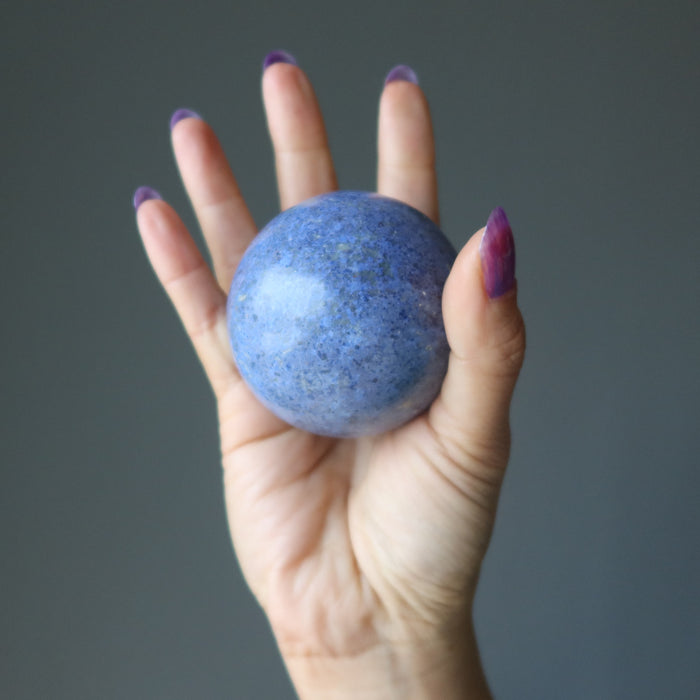 hand holding blue Dumortierite Sphere