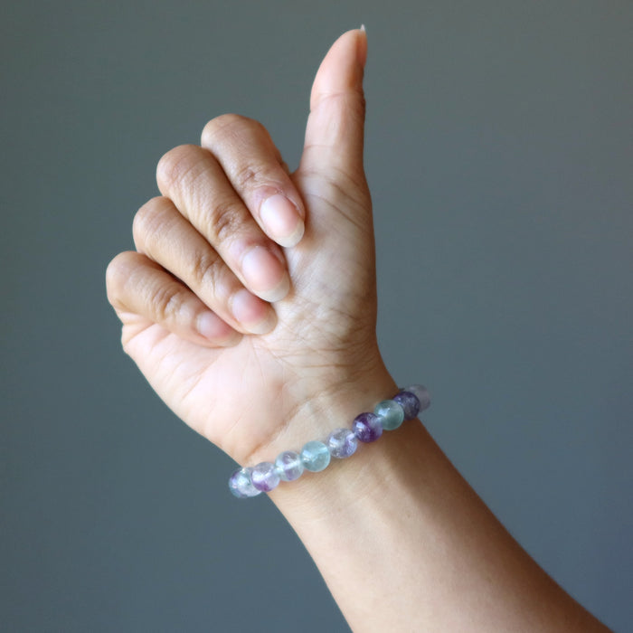 hand wearing a rainbow fluorite beaded stretch bracelet