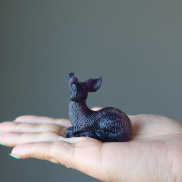 rainbow Fluorite Deer Figurine on model palm