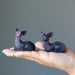 two rainbow Fluorite Deer Figurines on model palm