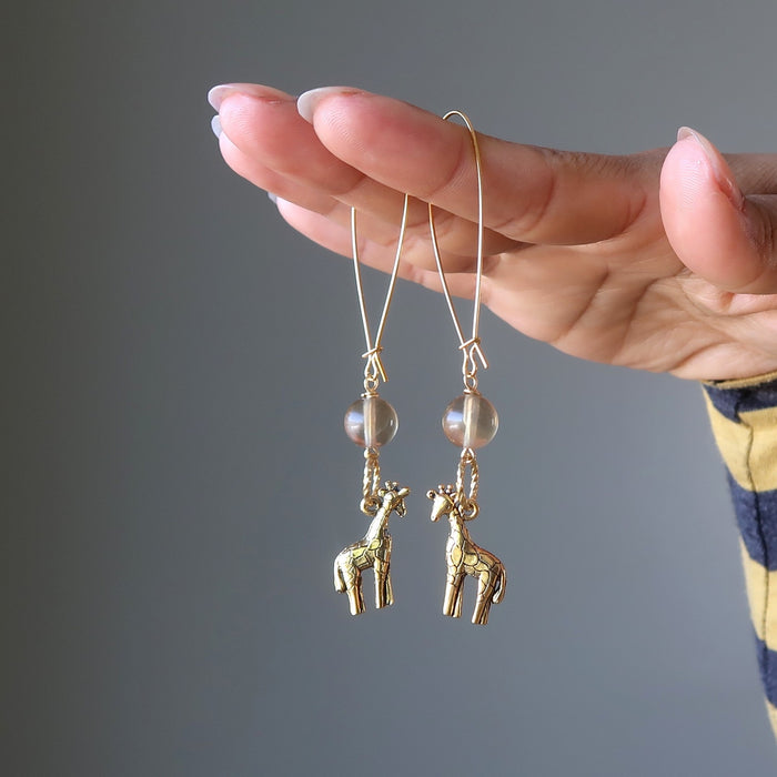 woman holding fluorite giraffee earrings