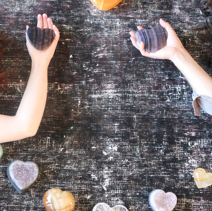 two model hands holding Purple Fluorite Heart