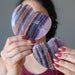 sheila of satin crystals holding Purple Fluorite Heart on each hand