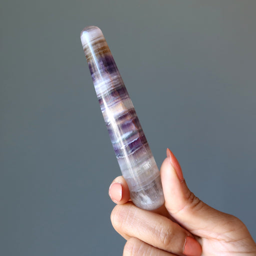 hand holding rainbow fluorite tapered massage wand