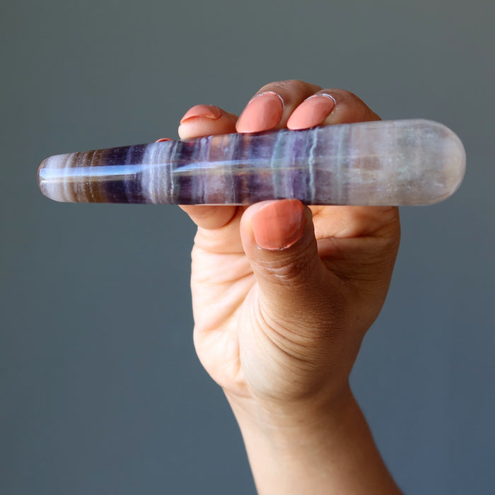 hand holding rainbow fluorite tapered massage wand