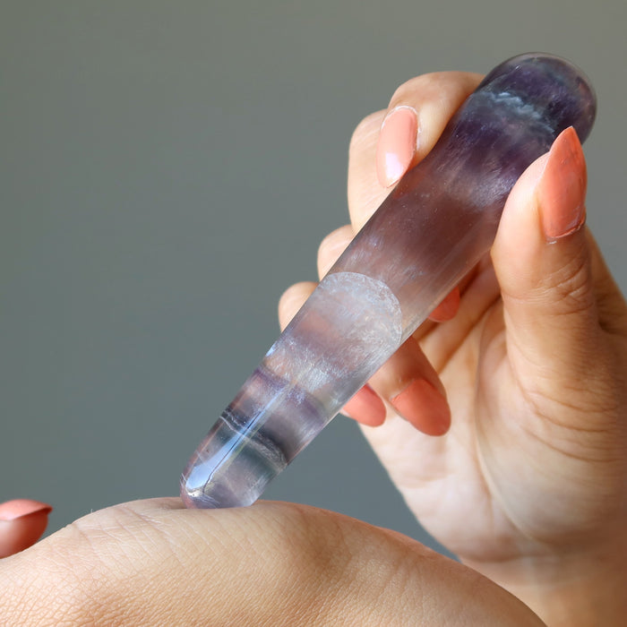 hand holding rainbow fluorite tapered massage wand