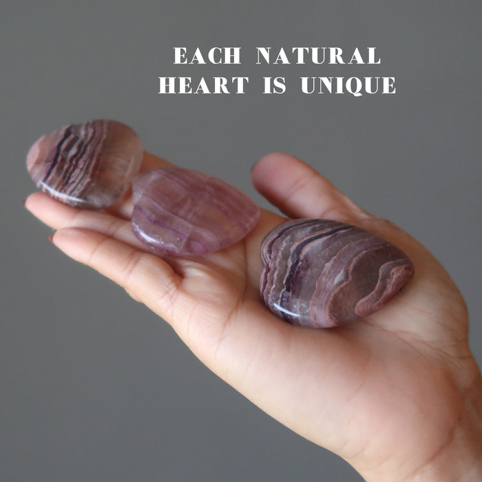 palm holding 3 Fluorite Hearts