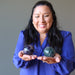 model holding green purple rainbow Fluorite Spheres one on each hand