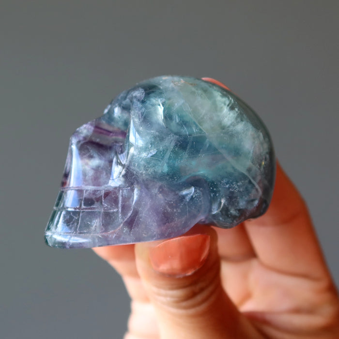 hand holding green purple rainbow Fluorite Skull
