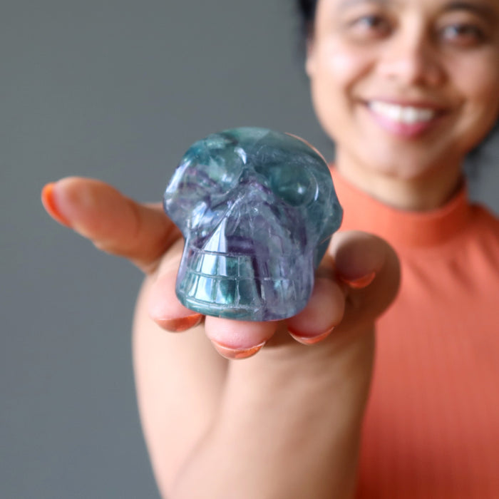 sheila of satin crystals holding green purple rainbow Fluorite Skull
