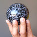 hand holding Indigo Merlinite Gabbro Sphere