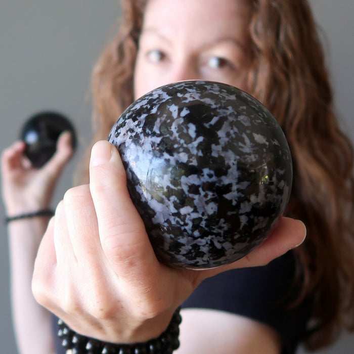 model holding Indigo Merlinite Gabbro Sphere