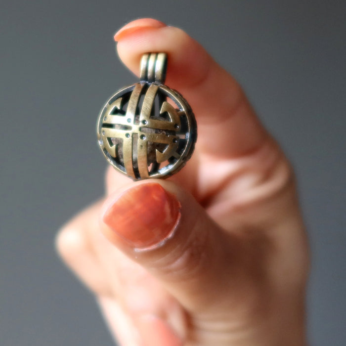 hand holding gao-guenie meteorite pendant