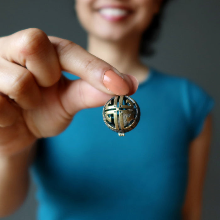 hand holding gao-guenie meteorite pendant