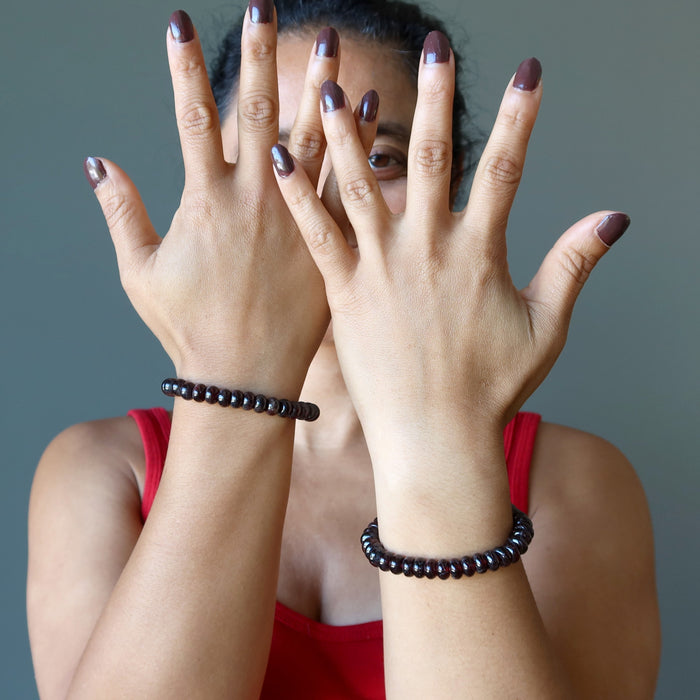 red garnet rondelle bracelets on woman's wrists