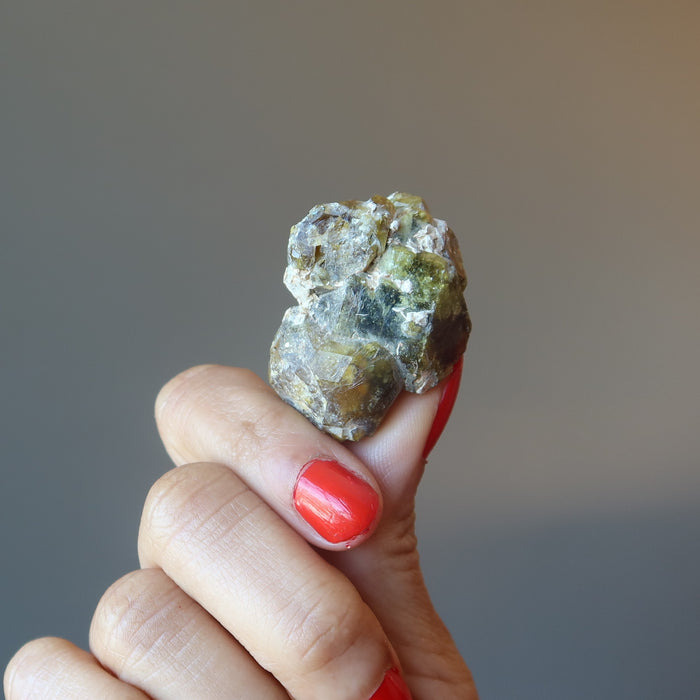 hand holding raw green garnet