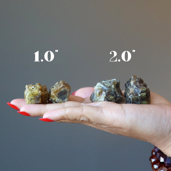 hand holding raw green garnet pairs