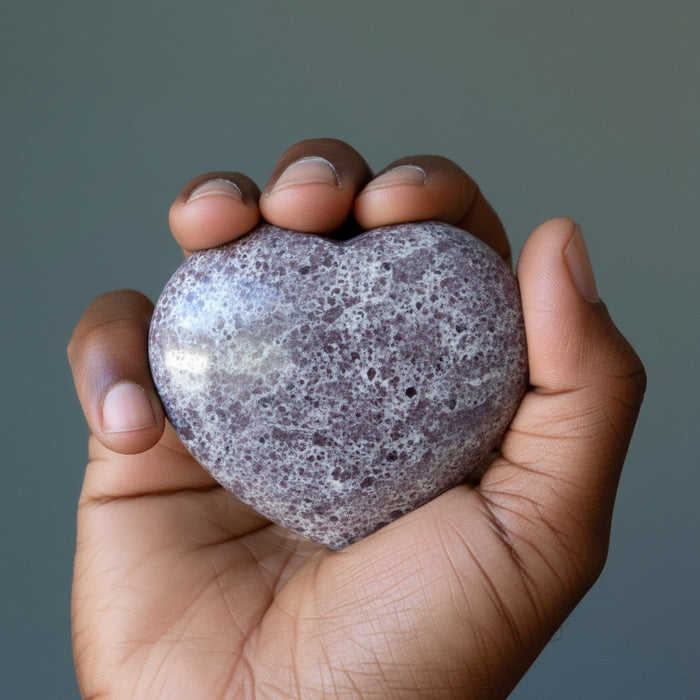 hand holding spotted dark red garnet heart