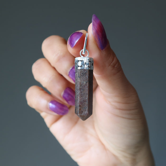 hand holding garnet point pendant