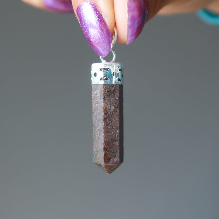 hand holding garnet point pendant