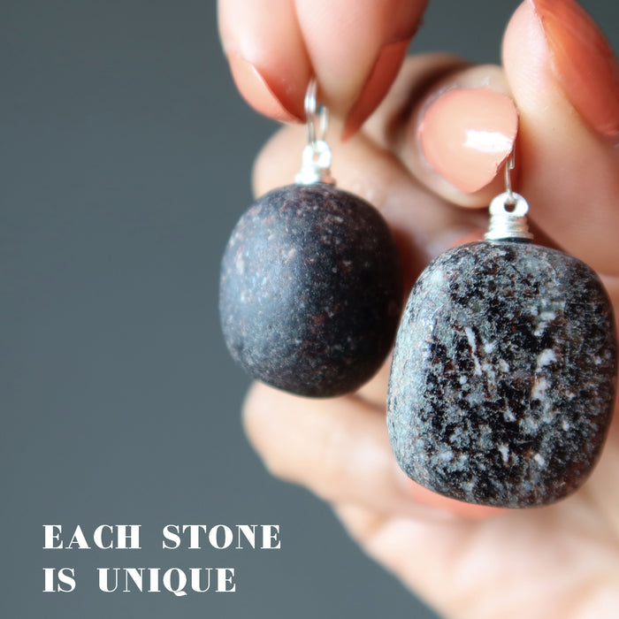 holding two unique garnet nugget pendants